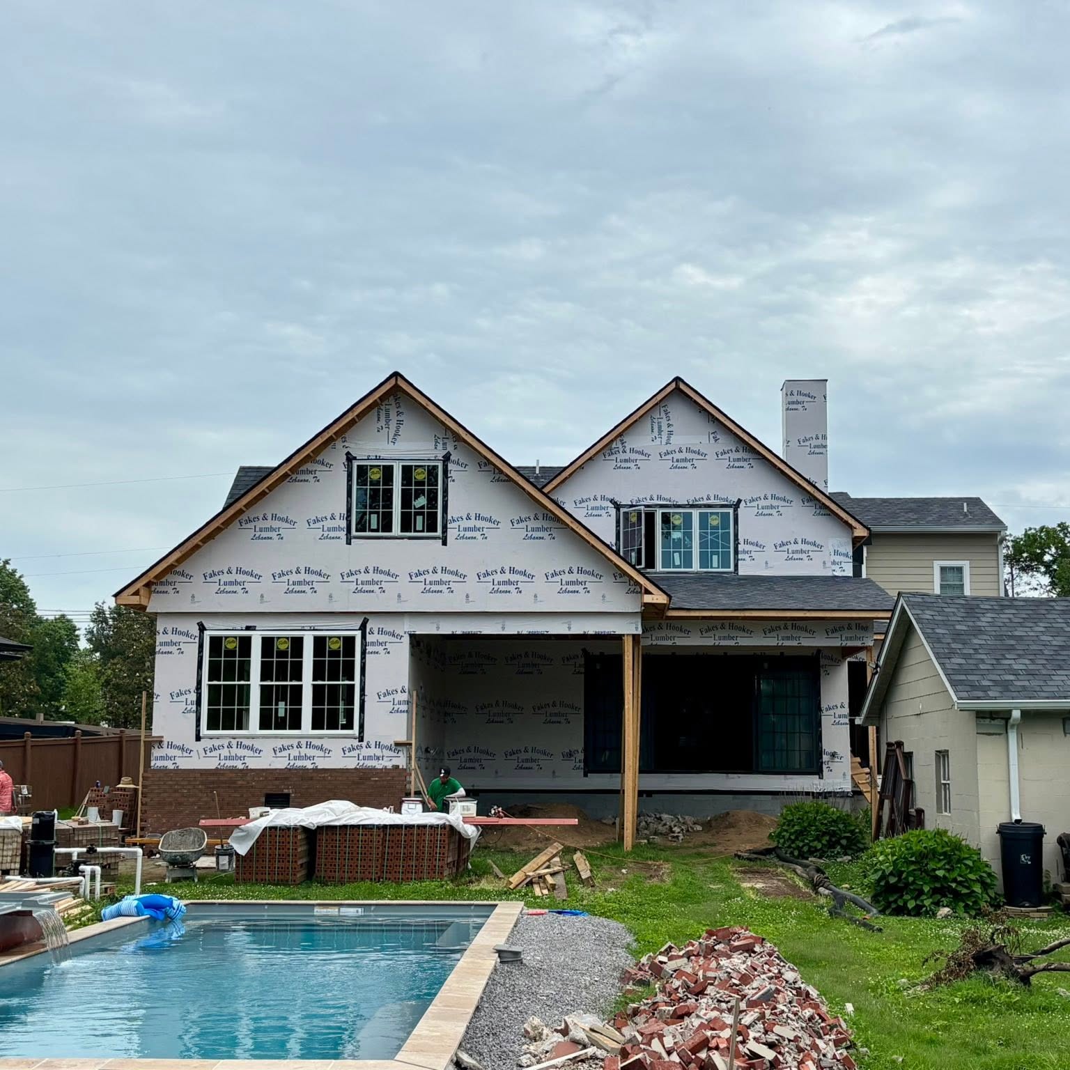 Home addition under construction with a new pool in the backyard
