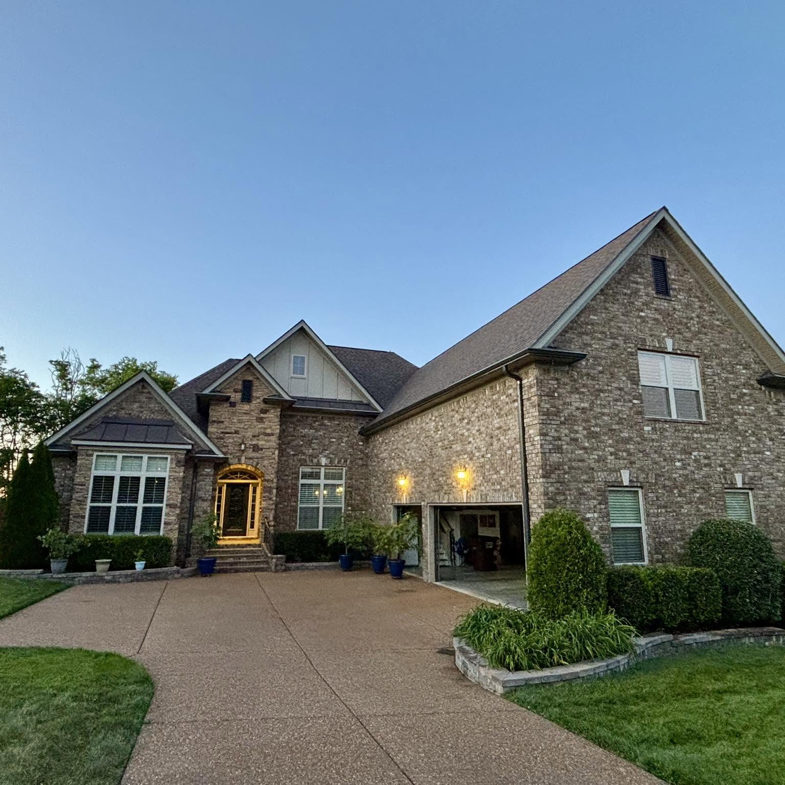 Stone and brick home with a new roof at dusk